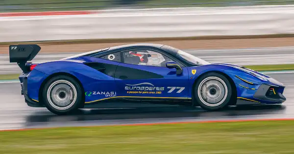 Ferrari 488 Challenge in Eurospares racing livery on the track, going fast with blurred background.