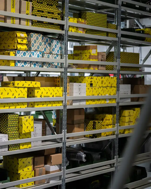 Inside the Eurospares warehouse, showcasing shelves stocked with supercar OEM parts in original manufacturer branded packaging, ready for distribution.